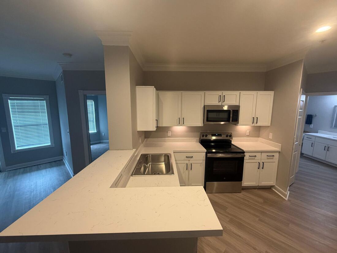 Apartment kitchen with white quartz countertops and a breakfast bar