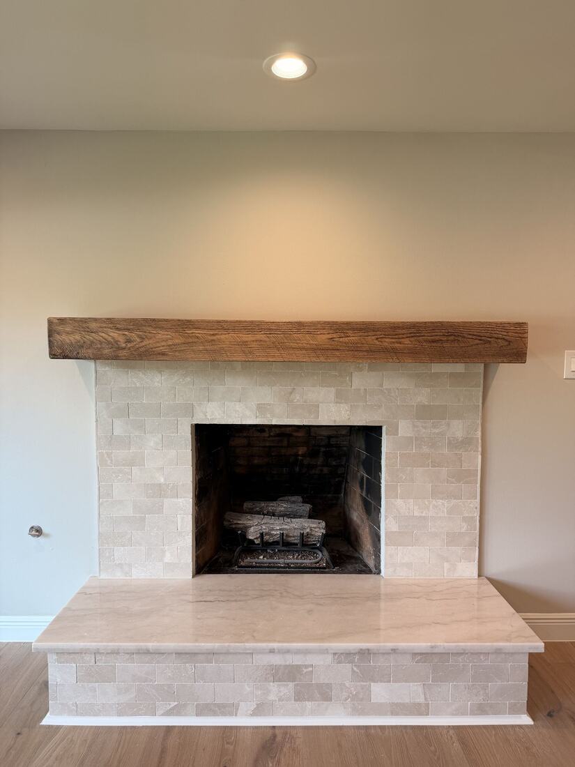 Raised quartzite hearth with a tile surround and reclaimed wood mantel