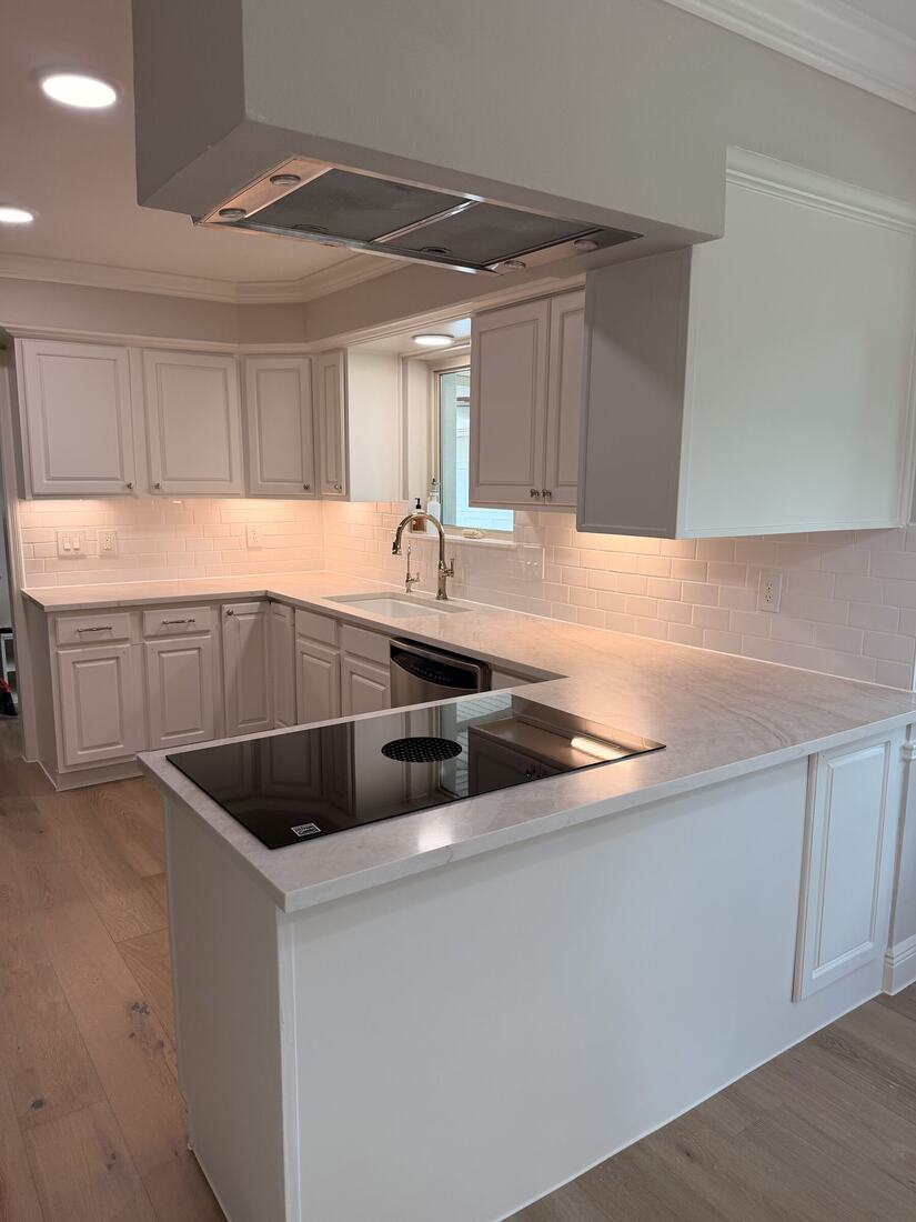 U-shaped kitchen with a soft quartzite countertop and induction cooktop