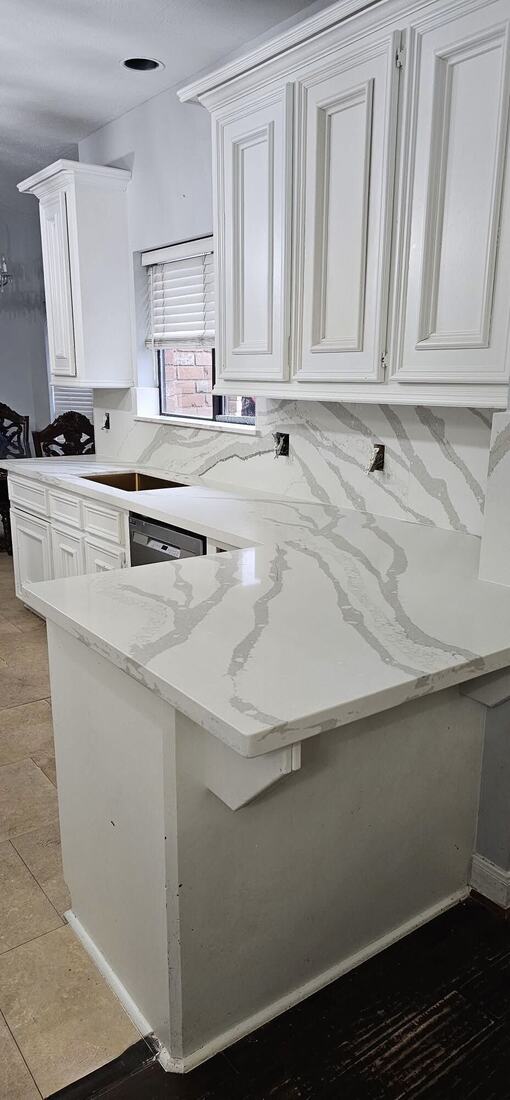 White quartz peninsula with a veined full-height backsplash