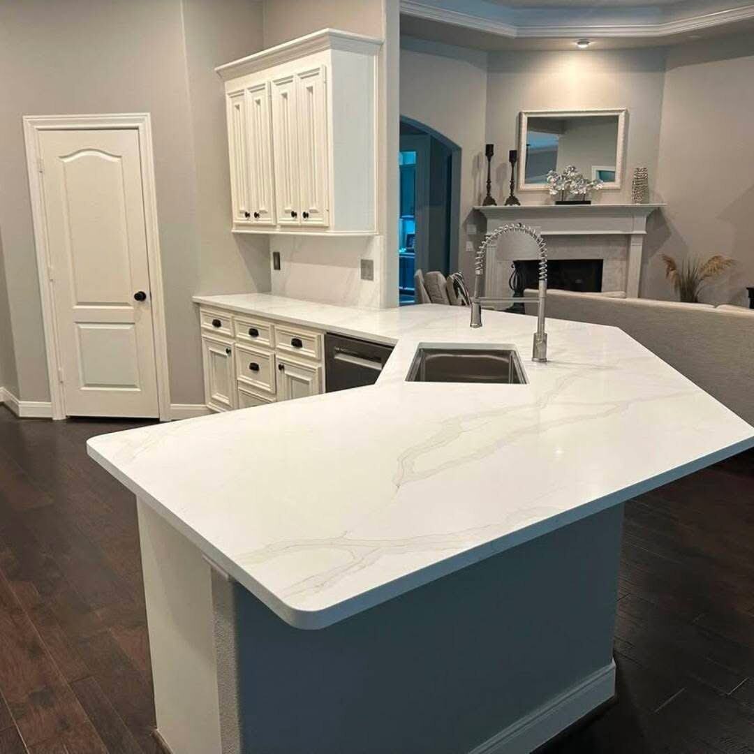 White quartz angled peninsula and sink in an open-plan kitchen