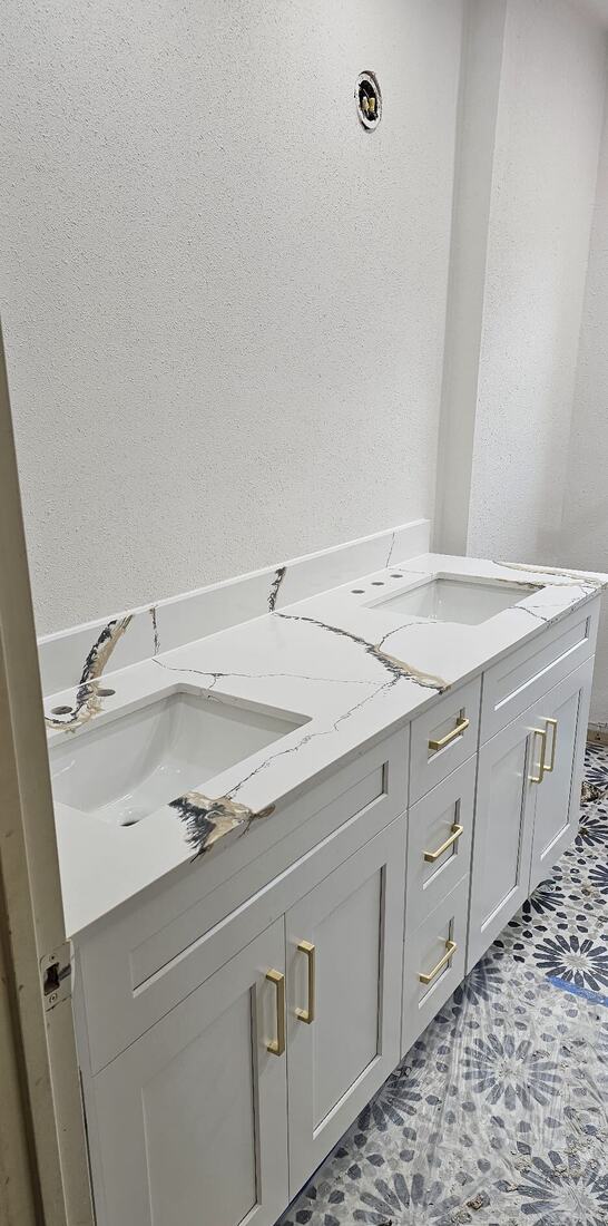 Double vanity with gold-veined quartz and brushed-gold pulls